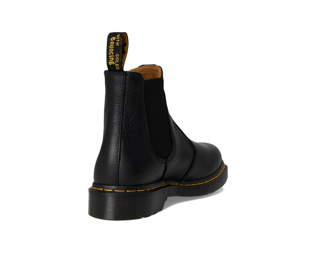 Unisex black leather Chelsea boot back view with elastic gore and yellow welt stitching