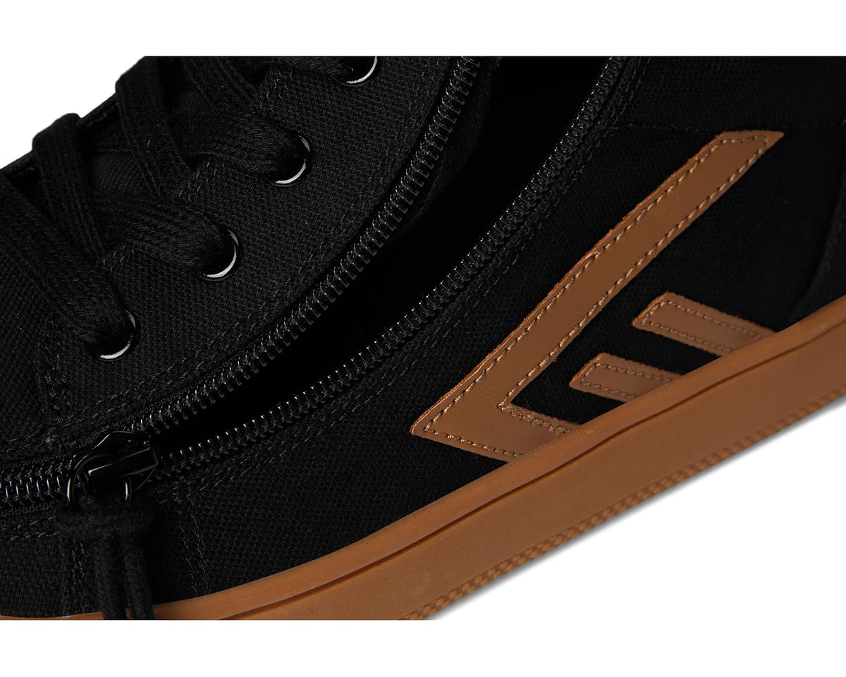 Detail view of black canvas high top shoe with lace eyelets, side zipper, tan trim