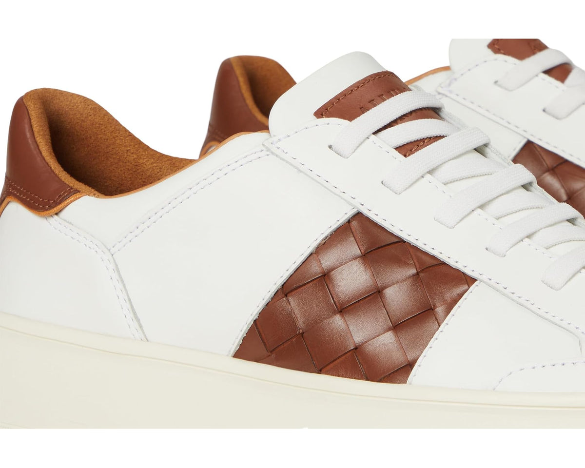 Men's white sneakers close-up: brown woven leather center panel and white laces