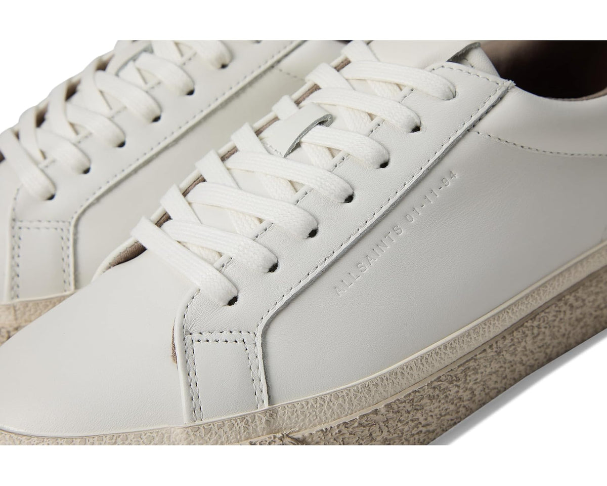 Men's white leather low-top sneakers, close-up of laces and side stitching
