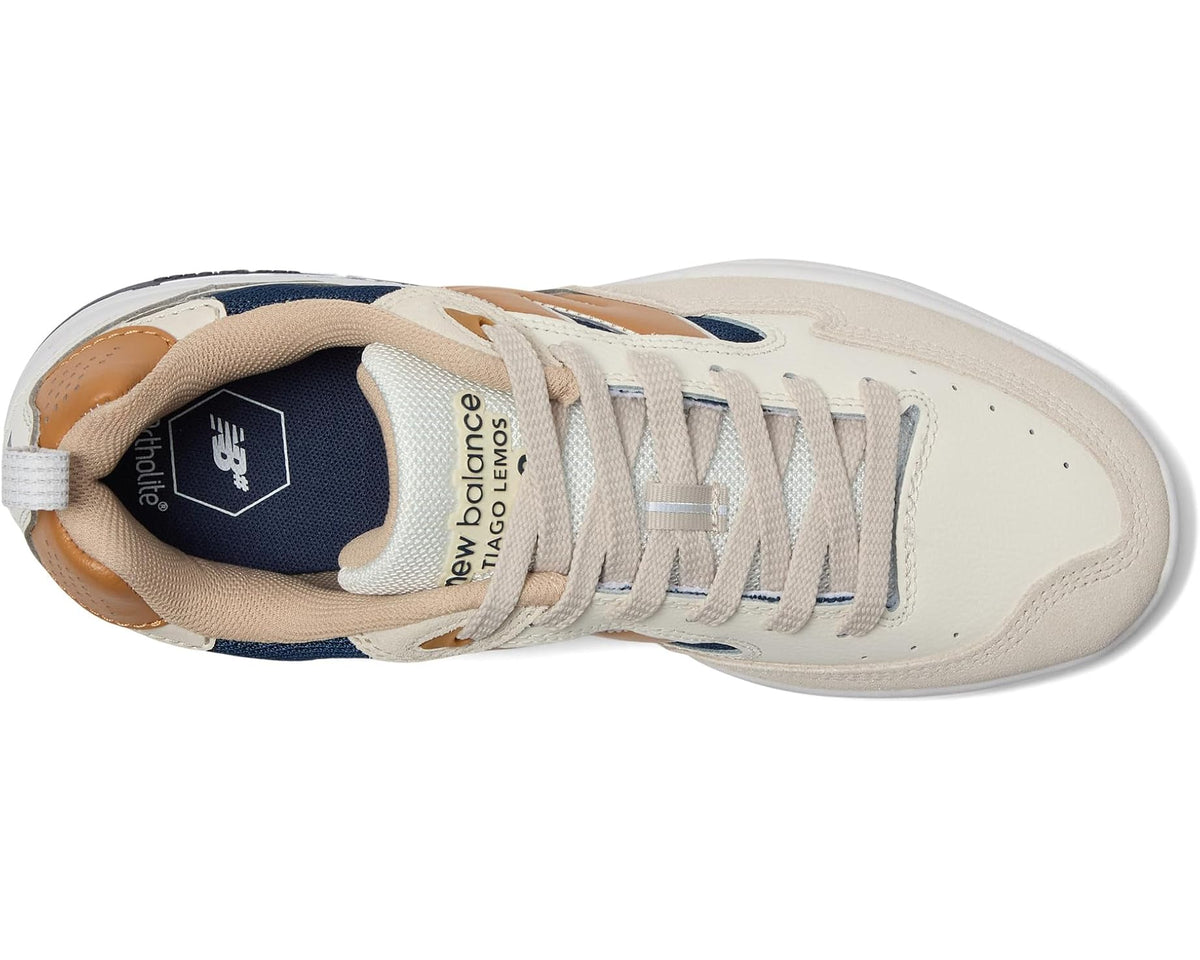 New Balance sneakers side view, cream upper with navy lining and tan overlays