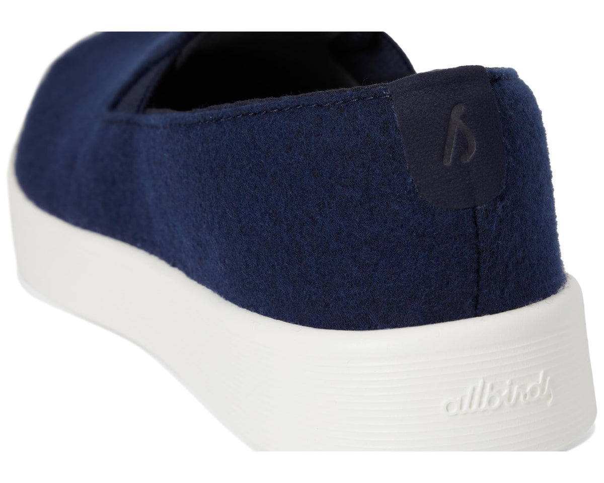 Heel and side view of dark navy wool slip-on shoes with embossed allbirds logo
