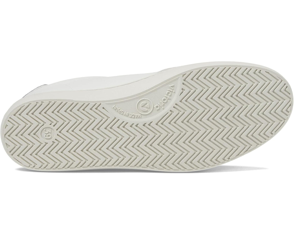 White sneaker outsole with chevron tread pattern and textured rubber grip