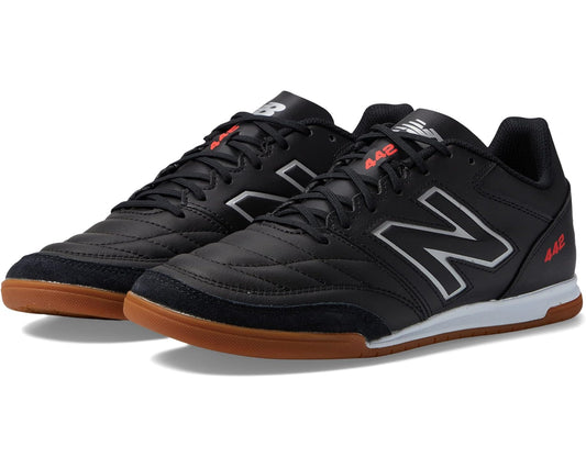 Black leather-look soccer cleats with white New Balance N logo and gum sole