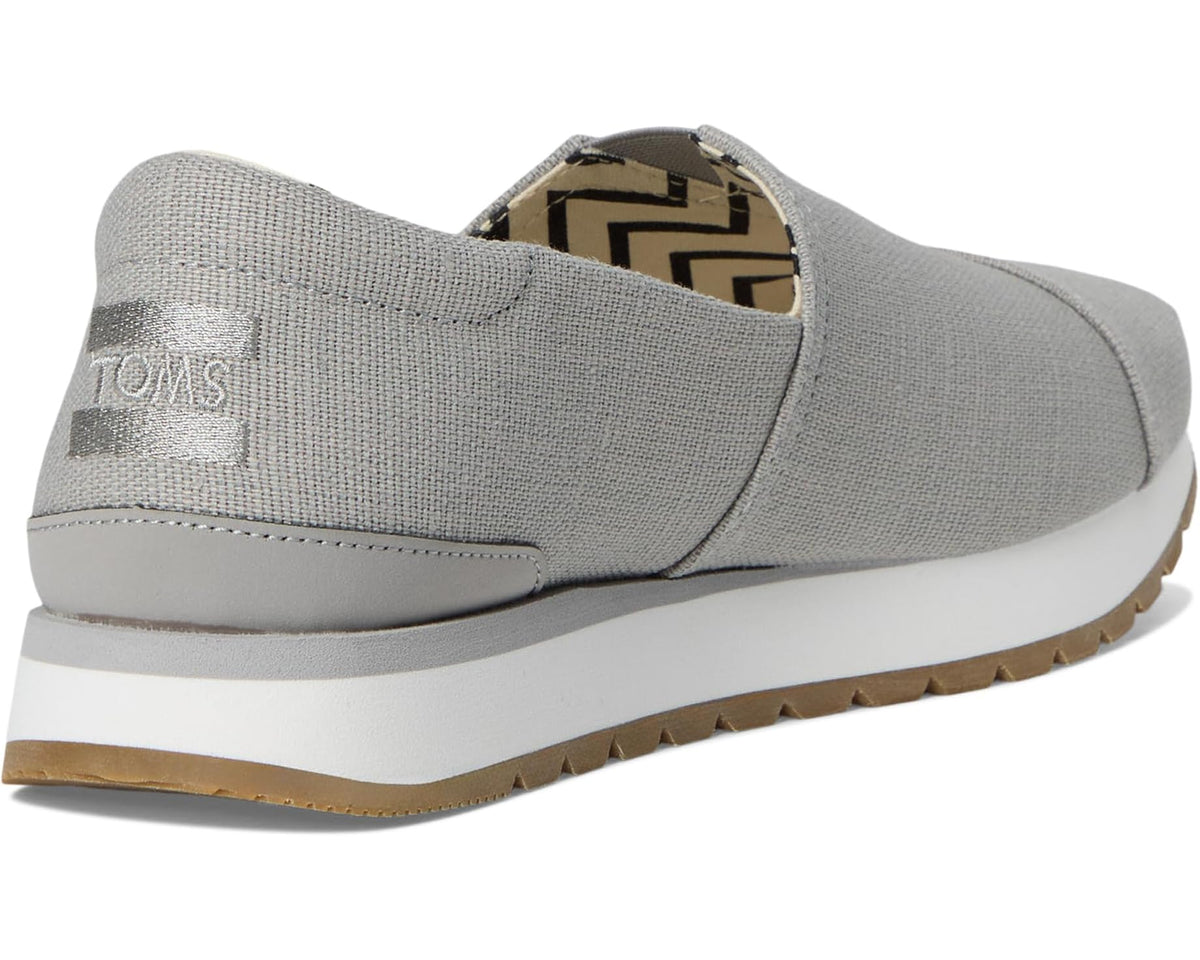 Men's TOMS slip-on shoes, grey upper with white midsole and brown outsole edge.
