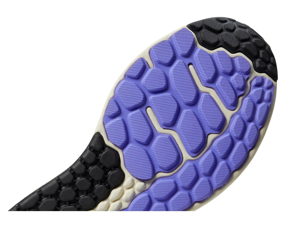 Men's New Balance running shoe outsole with purple tread pattern and black nubs