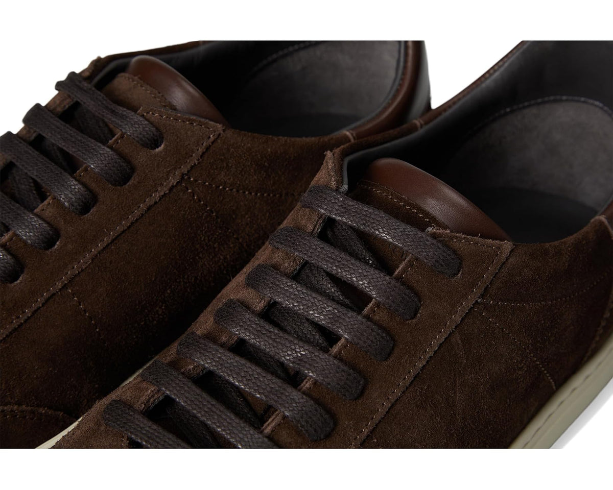Dark brown suede sneakers close-up with black laces and stitched side panels