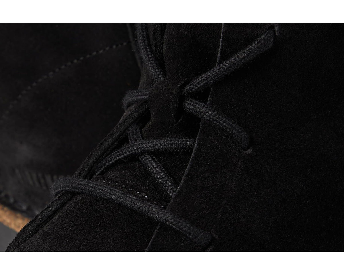 Close-up of black suede laces and seam on mid lace-up boots