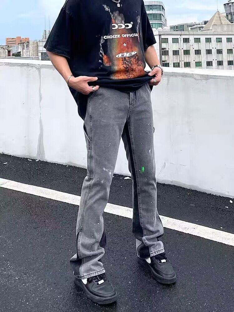 Gray denim jeans with front seam lines, paint splatters, and cuffed hems