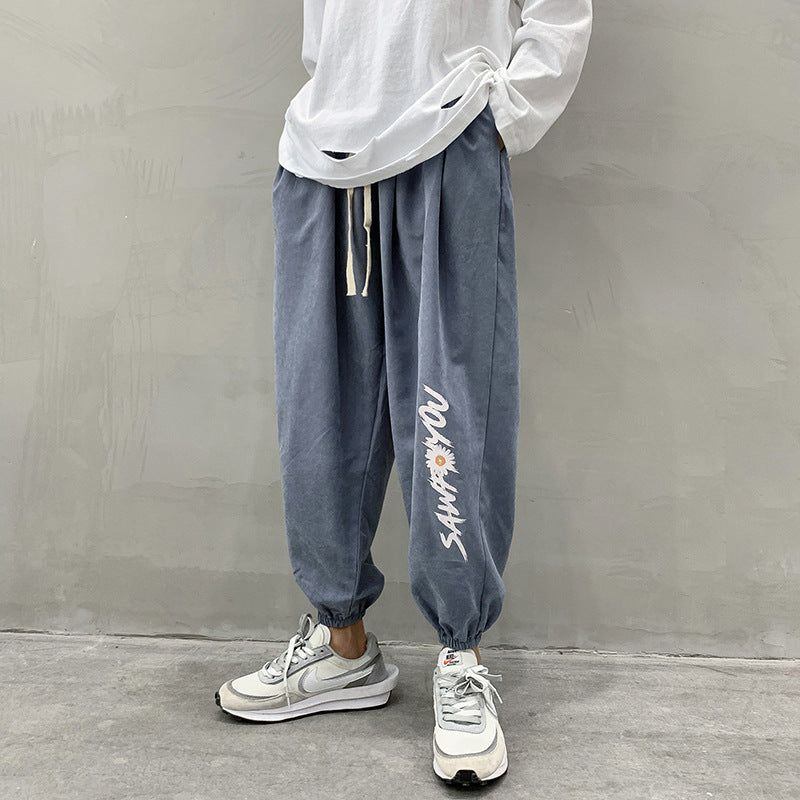 Blue jogger trousers with drawstring waist and vertical white side script logo