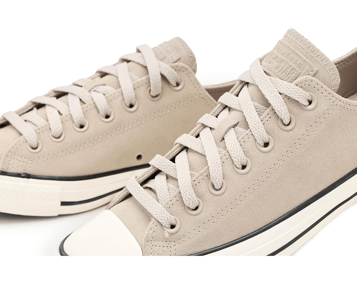 Converse suede low-top sneakers close-up, beige laces and eyelets with black detail