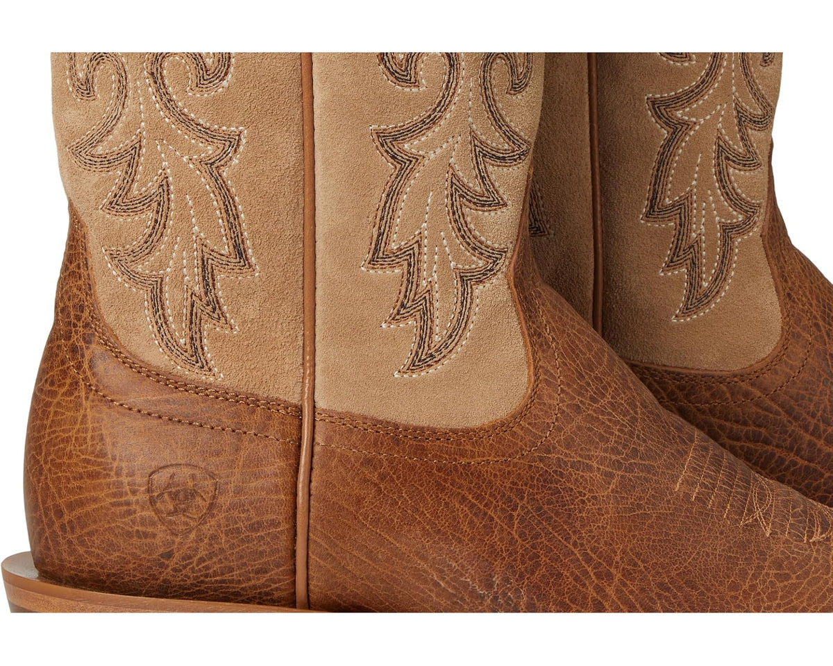 Close-up of tan cowboy boot shaft with floral embroidery and textured leather