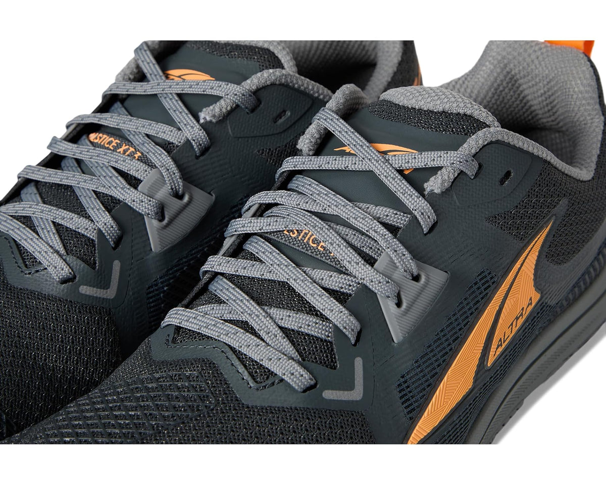 Men's dark gray running shoe close-up of laces and orange side stripe