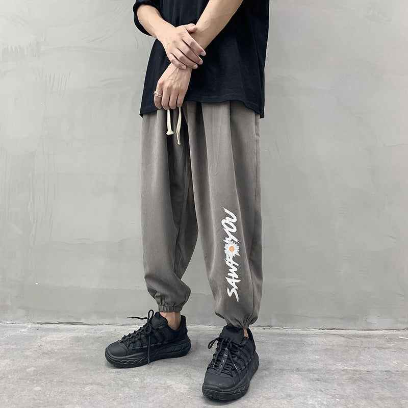 Charcoal gray jogger trousers with white drawstring and white side script graphic