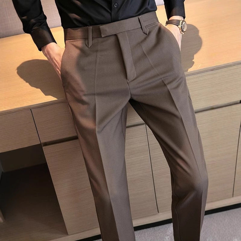 Men's brown dress pants with belt loops, pleated front, and tapered trouser legs