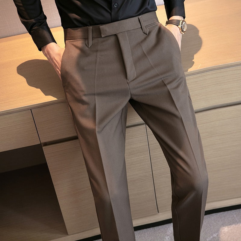 Men's brown dress pants detail: pleats, belt loops, and slim tapered legs